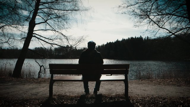 Man sitting on a bench a sunny spring day