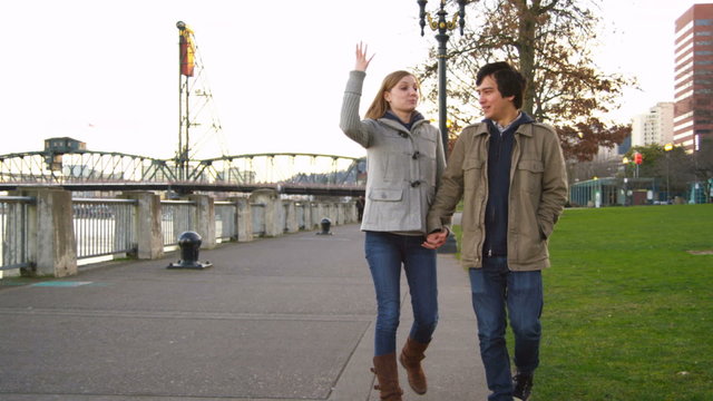 Young couple walking along waterfront, slow motion