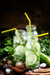 Cucumber fizzy drink with herbs and ice , selective focus