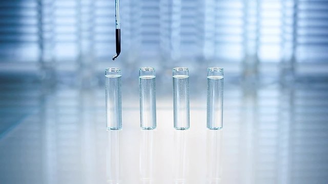 Laboratory. in a test tube with a pipette dripping blue liquid