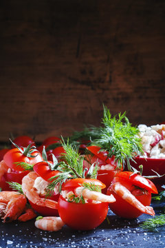 Tomatoes stuffed with shrimp and vegetables on a dark background