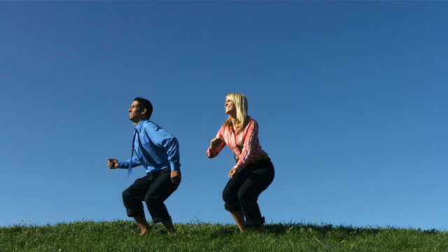 Two business people jumping in slow mo