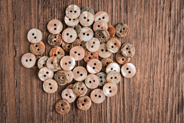 Obraz premium Set of different colored buttons over rustic wooden texture.