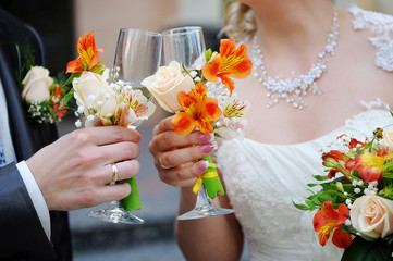 Bride and groom are holding champagne glasses