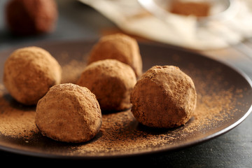 Sweet chocolate truffle on a black wooden table