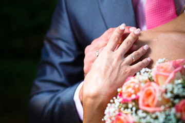 Obraz na płótnie Canvas Hands with wedding ring on brides shoulder