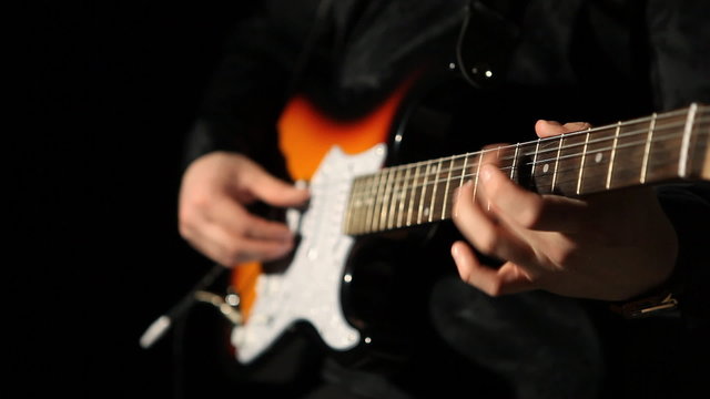 guitarist playing guitar on a black background