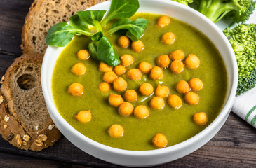 Italian broccoli soup or cream soup on wooden table.