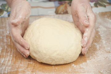 Hands baking dough with rolling pin