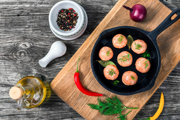 meatball on a frying pan prepared for cooking, top view