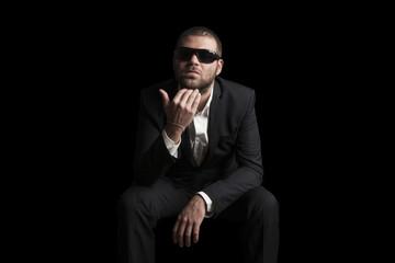 portrait of a tough cool man with sunglasses on balck background