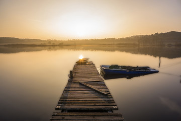 Sonnenaufgang am Ulmener Weiher mit Boot am Steg 