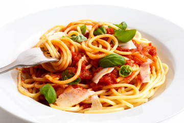 Detail of spaghetti rolled onto fork, tomato sauce, basil and ch