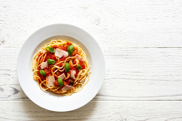 Spaghetti with tomato sauce, fresh basil and cheese. Isolated on