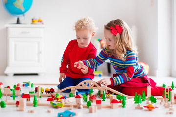 Naklejka premium Children playing with toy railroad and train