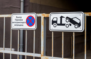 Traffic sign prohibiting parking mounted on metal gate. Evacuati