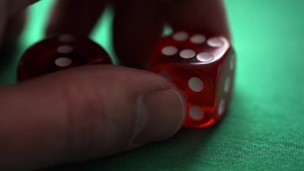 Red dice in hand on green table
