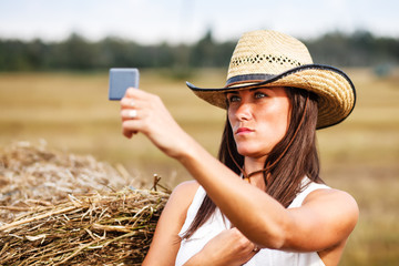 Woman in cowboy hat looking at the mirror.