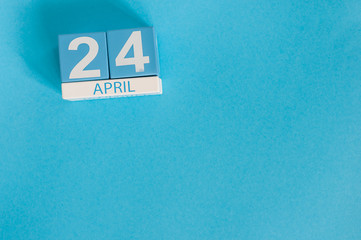 April 24th. Image of april 24 wooden color calendar on blue background.  Spring day, empty space for text. World Immunization Week