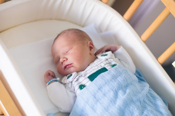 Newborn baby boy in hosptal cot