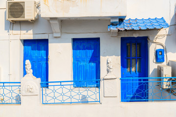 Facade of Greek house with blue door and windows in Pythagorion town, Samos island, Greece