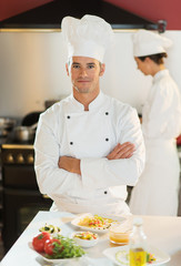 Portrait of a cook chef standing in the kitchen arms crossed.