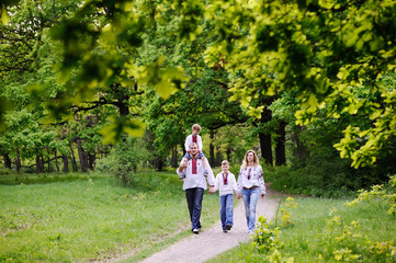 Naklejka na ściany i meble family in Ukrainian embroidered shirts are on a path in a forest
