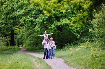 family in Ukrainian embroidered shirts on forest background