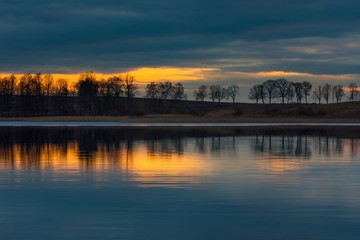 Fototapeta premium Close up of opposite shore of lake after sunset