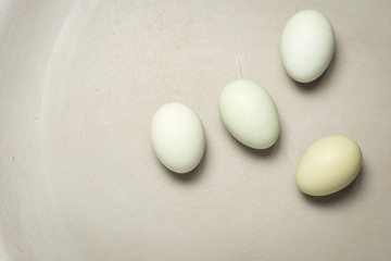 Four blue eggs on a blue grey plate