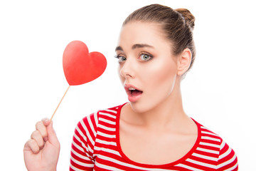 Surprised woman holding red paper heart on stick