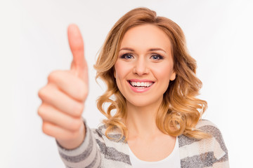 Cheerful girl with curly hair showing thumb up