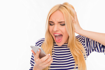 Shocked frustrated young woman holding phone and screaming