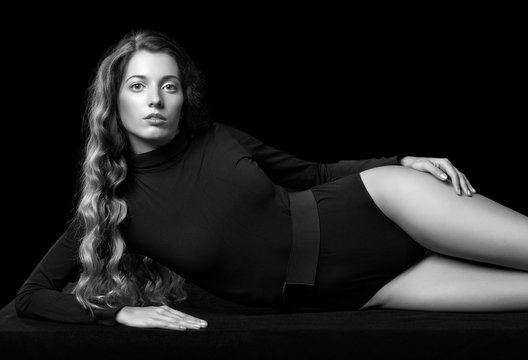 Portrait of beautiful caucasian model posing on black cloth on b