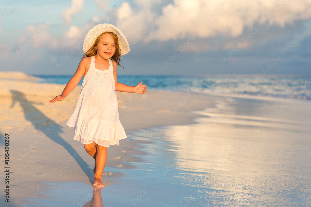 Wall mural little girl walking on beautiful ocean beach