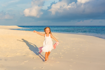 Little girl playing on beautiful ocean beach