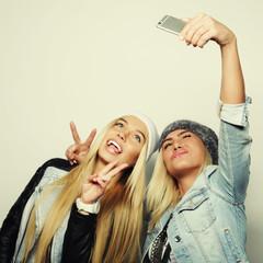 Two teenage girls friends in hipster outfit make selfie 