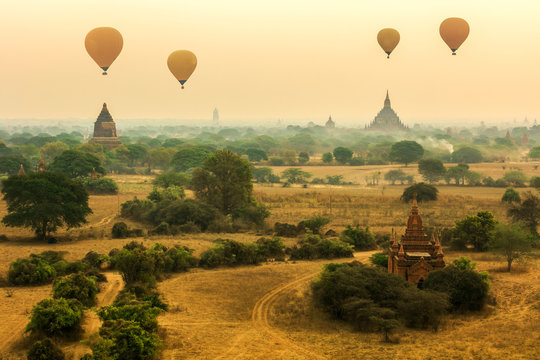 Air balloons flying over pagodas at misty morning in the plain o
