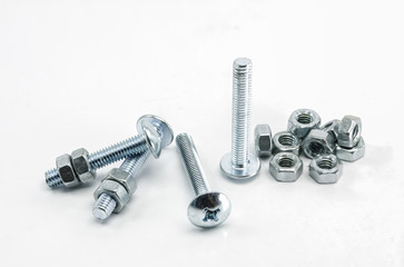 Metal bolts and nuts on white background.