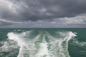 waves from the boat and cloudy sky