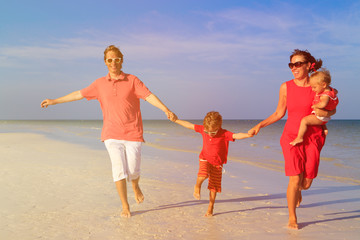 family with two kids having fun on tropical beach