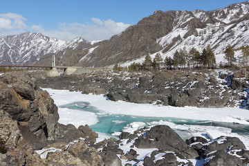 Fototapeta na wymiar Opening of ice on the turquoise Katun River in the spring near Oroktoysky Bridge, Altai, Russia 