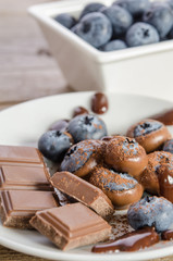 Chocolates and cocoa powder with blueberries in a porcelain dish