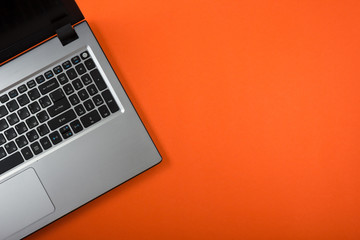 Office table desk with set of colorful supplies, white blank note pad, cup, pen, pc, crumpled paper, flower on red background. Top view and copy space for text
