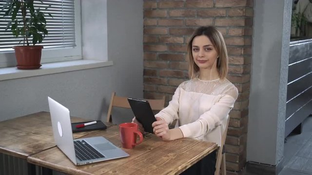 Attractive woman making a video call by tablet.