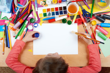 Child drawing top view. Artwork workplace with creative accessories. Flat lay art tools for painting.