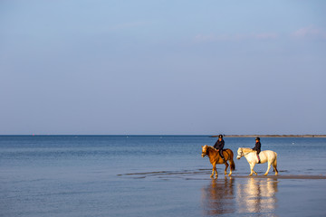 Zwei Kinder reiten am Strand von Laboe