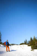 The climber goes on the snow slope.