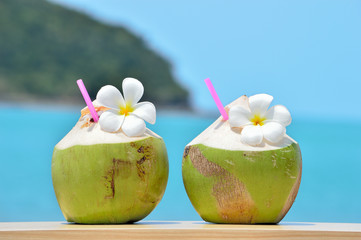 Tropical fresh coconut cocktail decorated plumeria on tropical c - 105499276