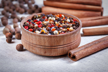 Spices in a wooden bowl, ceramic spoon, pepper, thyme, cinnamon,